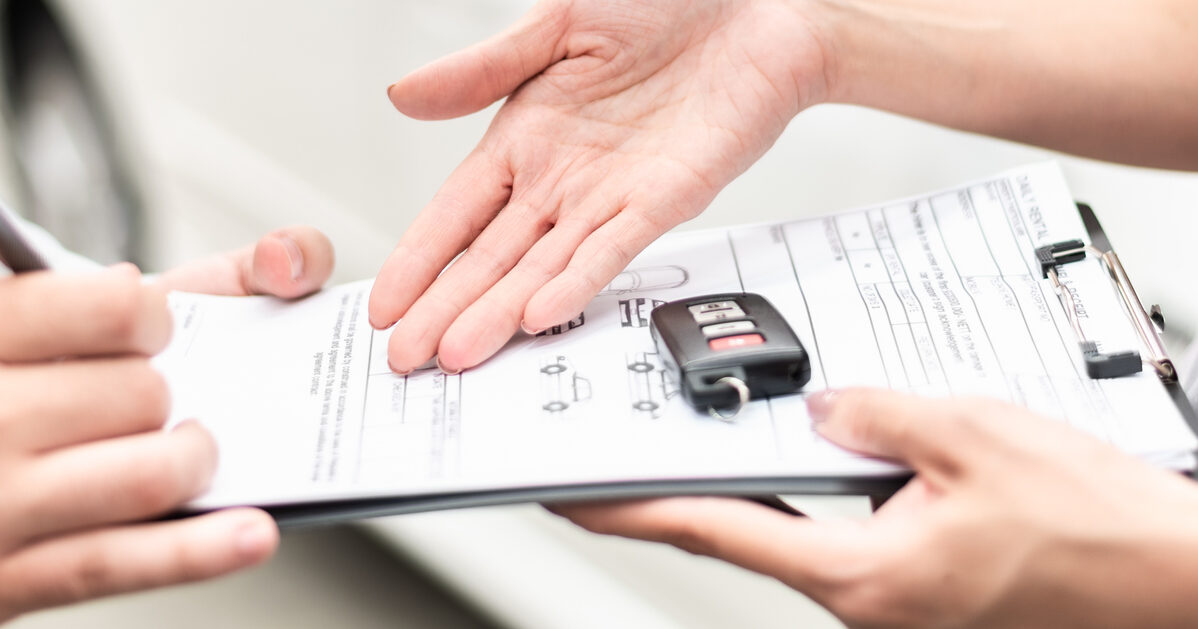 Automotive business, car sale or rental concept : Happy customer with car dealer agent making deal and signing on agreement document contract in auto showroom or car dealer office.